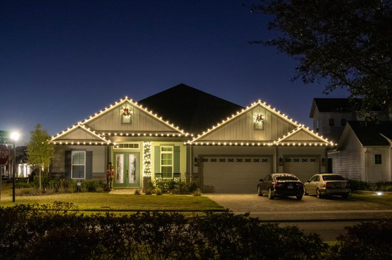 Home with C9 Christmas lights installed on the roofline in warm white