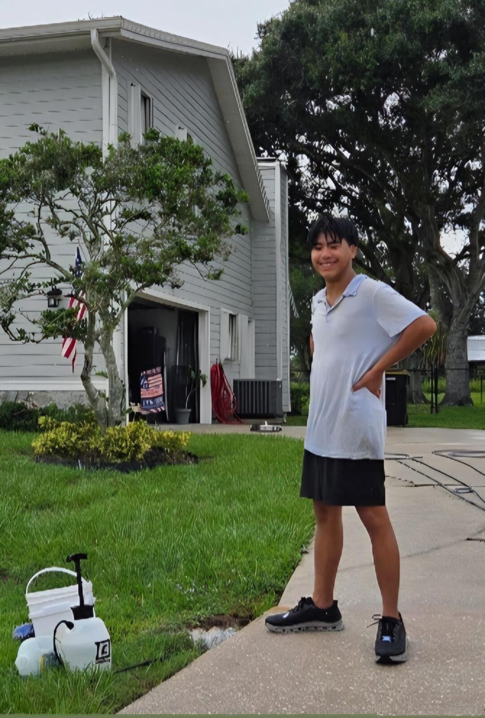 Seaton on the driveway of a two-story home after a whole-house clean