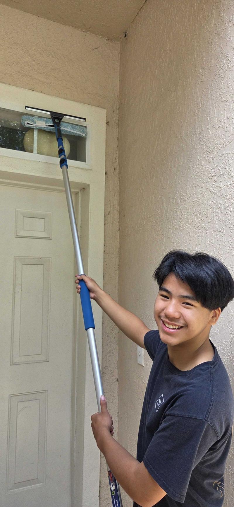 Seaton cleaning a front-door window with a squeegee