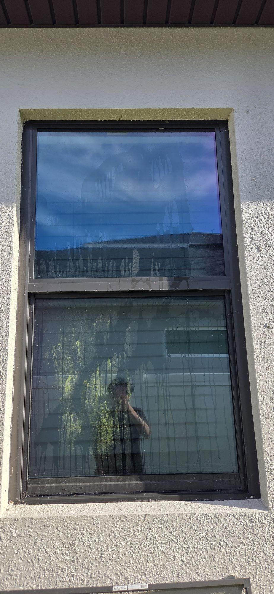 Before: exterior window with runoff streaks and hard-water spots