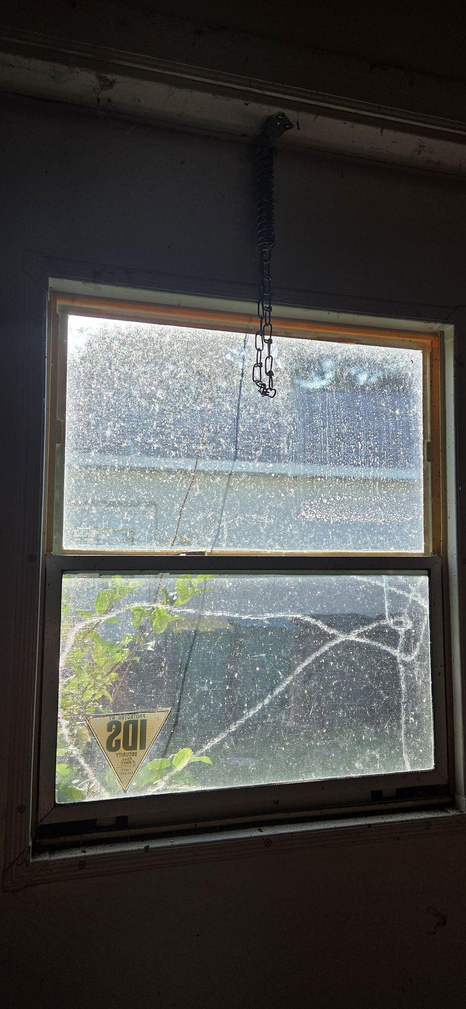 Before: inside of a window with heavy spotting on the glass