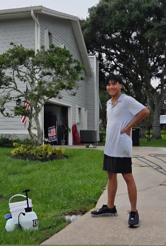 Seaton on the driveway of a two-story home after a whole-house clean